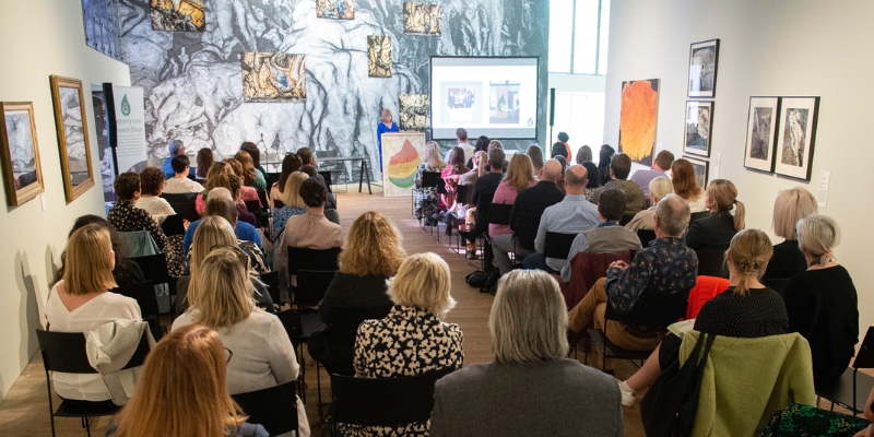 Audience of people, all seated in a gallery