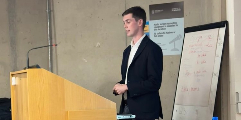 Side profile of a man standing at a podium speaking