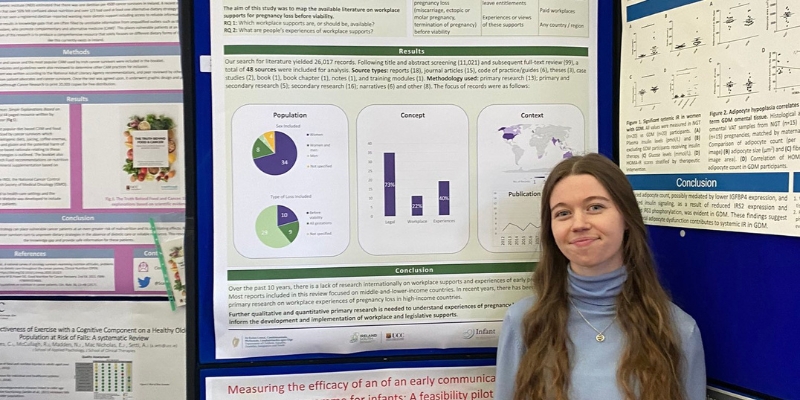 Woman standing in front of poster boards, smiling