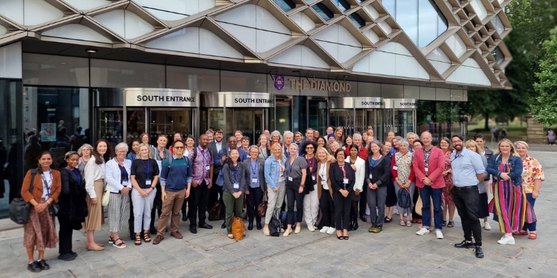 Large group of people standing outside a modern building/conference venue