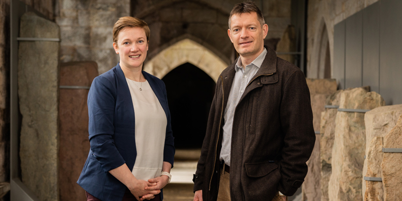 Two researchers standing in the UCC stone corridor