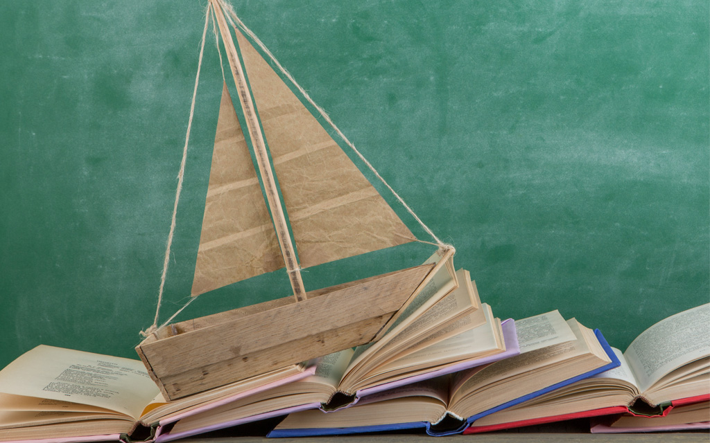 A wooden boat on books