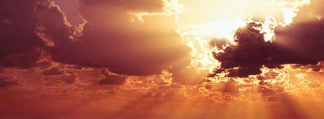 sun shining from behind dark clouds