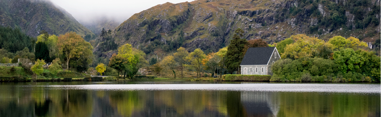 Church beside a lake with a mountain in the background.