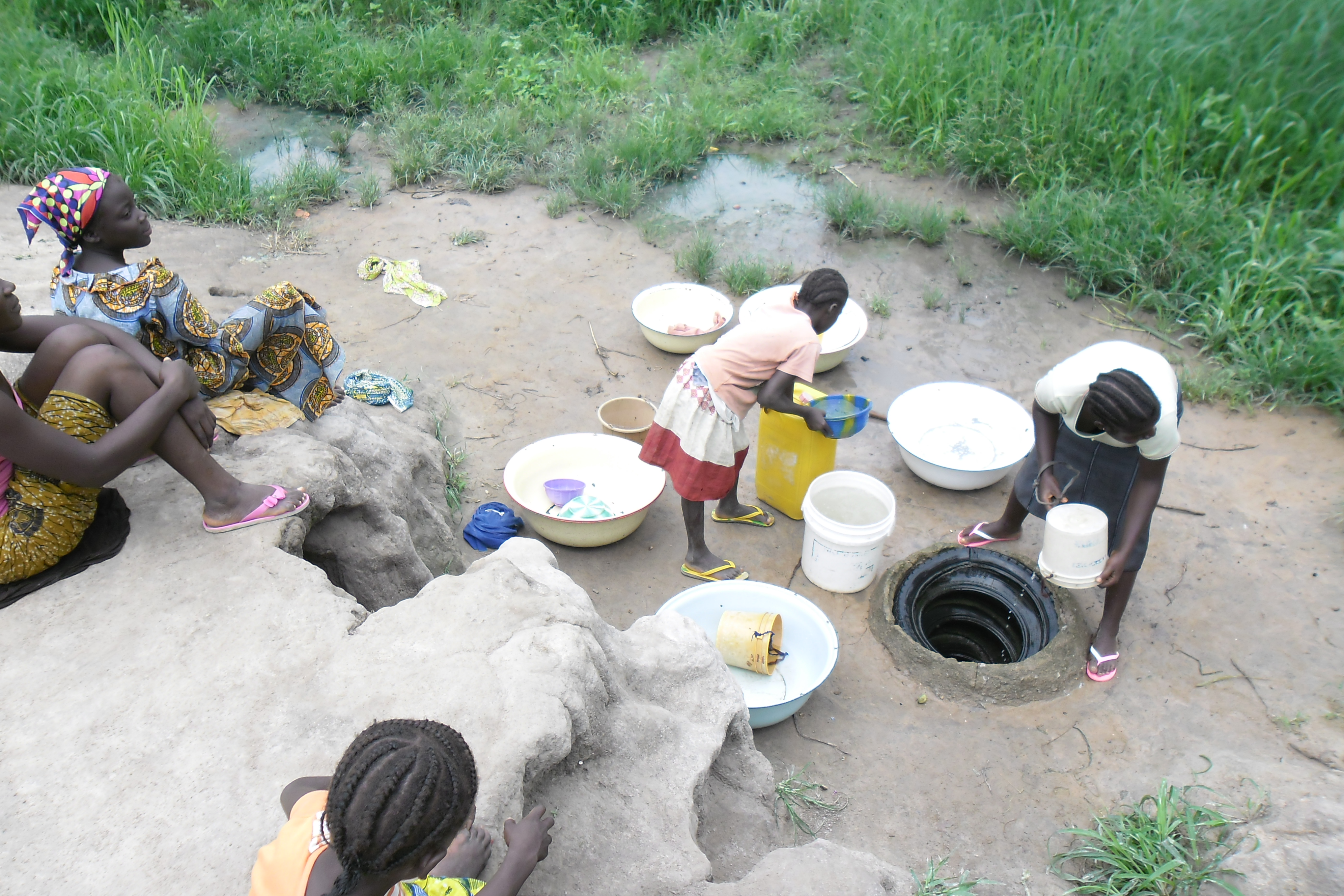 Young girls fitching water at the stream