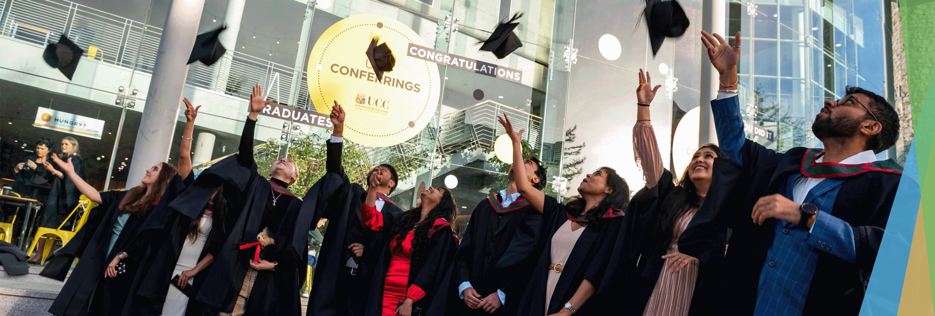 Group of international graduates throwing their caps in the air