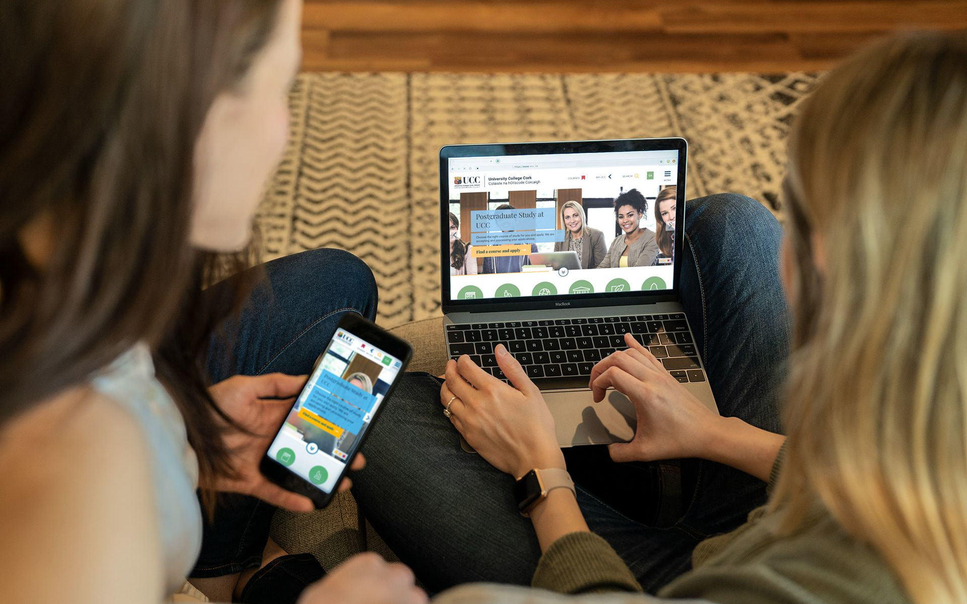 two women looking at the ucc homepage on a laptop and phone. Photo by mometrix on Unsplash.