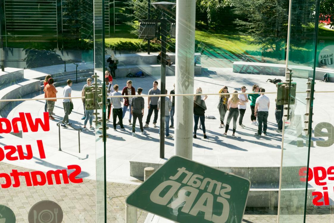 Looking through the student centre glass window at students in the amphitheatre on orientation week