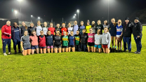 A photograph of the UCC women's football team in an official portrait on the pitch