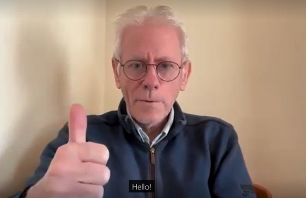 A man giving a thumbs up sign with the word 'Hello' in closed captions