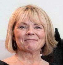 A close-up headshot of a smiling woman with pale skin and short blonde bobbed hair with a fringe.