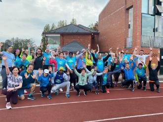 A group of people waving their arms in the air after completing a run.