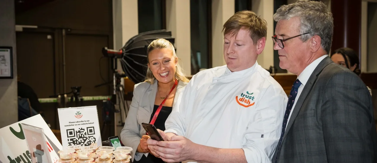 Three people looking at a smart phone