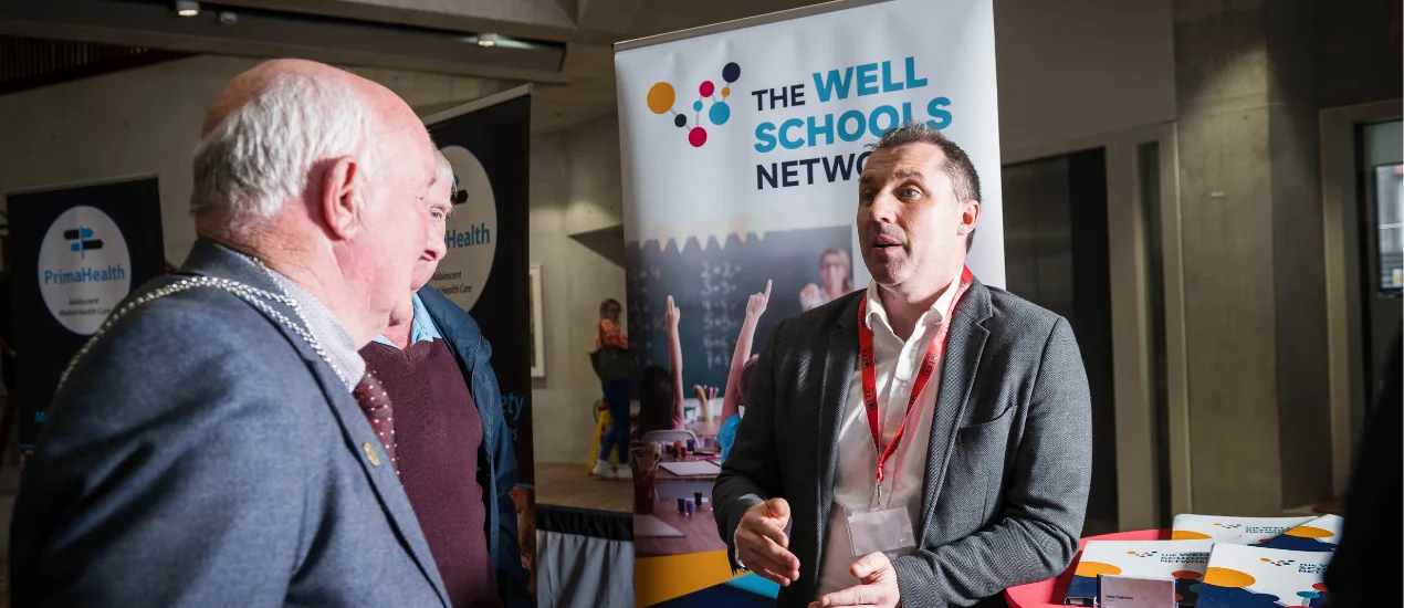 Two men talking to each other at an event