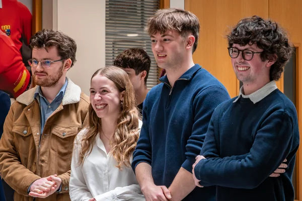 4 people standing and smiling