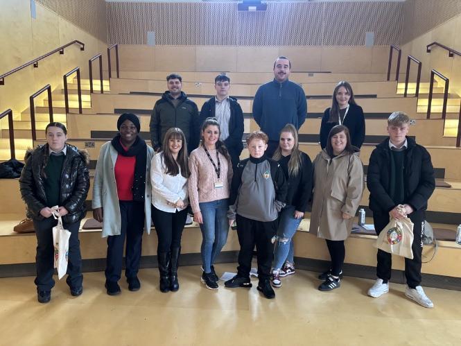 Gillian Butler, Paul Geelaher and Vivien Liston of Access UCC pose on the wooden steps of the Shtepps room with MTU Access representatives and a diverse range of students from the Traveller Community.