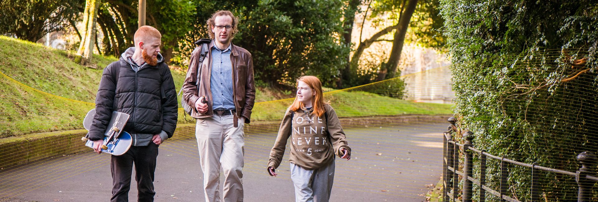 Access UCC Photoshoot - Three students walking outside in conversation by UCC