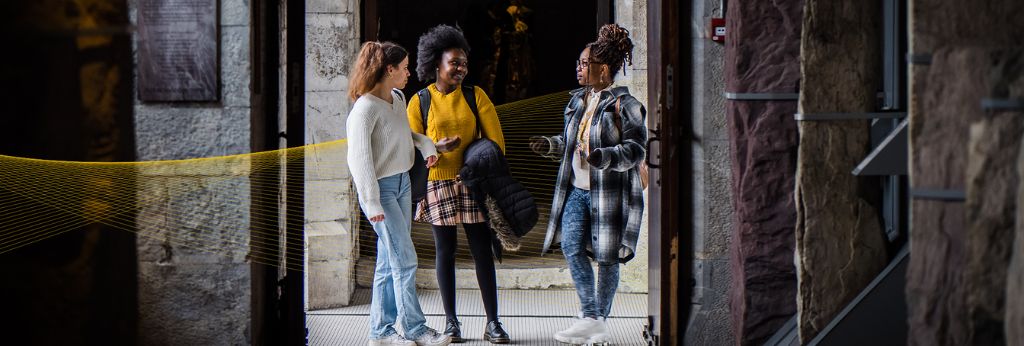 Access UCC Photoshoot - Three students talking by the arch in the West Wing UCC