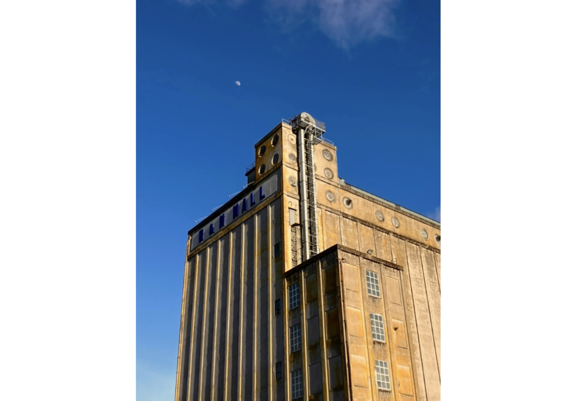 Photograph of R&H Hall, an industrial building. The sun is shining.