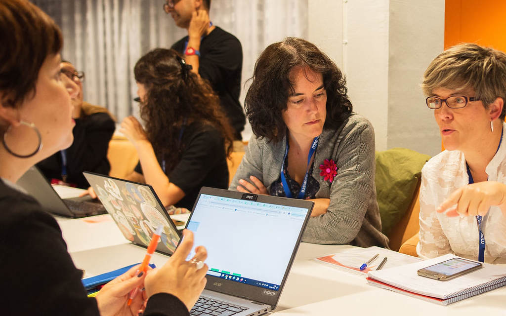 Three women interact at a conference